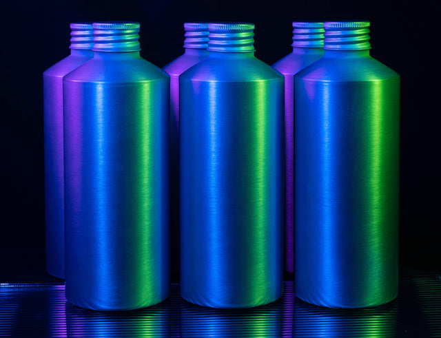 Aluminum screw cap packaging lined up in two rows and highlighted with neon lights