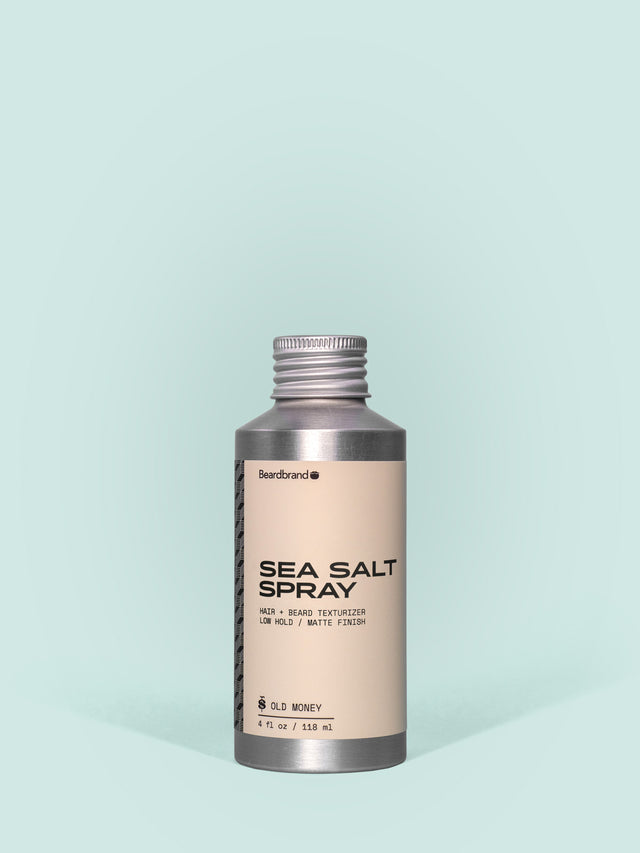 Beardbrand Sea Salt Spray in Aluminum packaging with a screw cap against a light blue background.