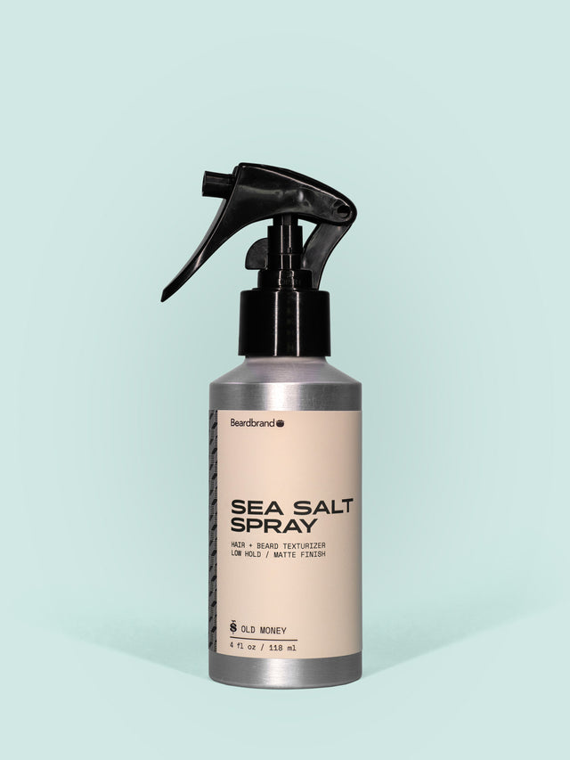 Beardbrand Sea Salt Spray in Aluminum packaging with spray dispenser against a light blue background.