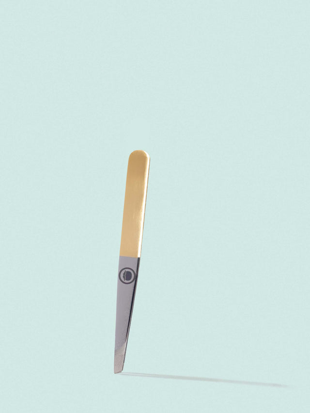 The slant tip Beardbrand Tweezers with two-tone stainless steel and the Beardbrand circle logo on a striking blue backdrop.