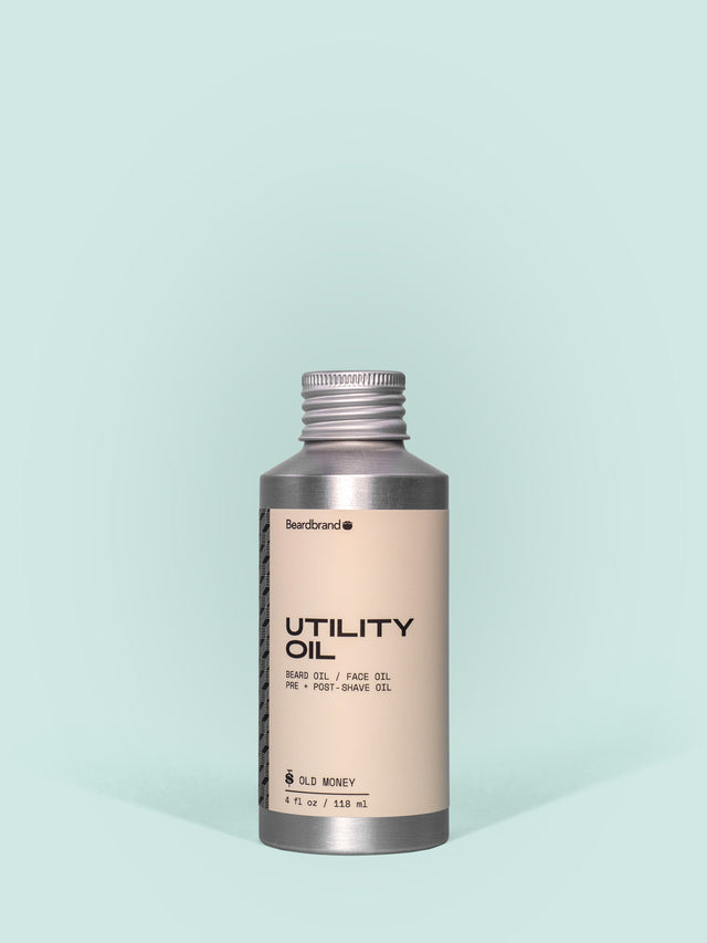 Beardbrand Utility Oil in Aluminum packaging with a screw cap against a light blue background.