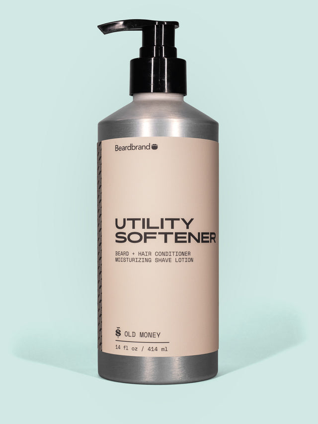 Beardbrand Utility Softener in Aluminum packaging with pump dispenser against a light blue background.