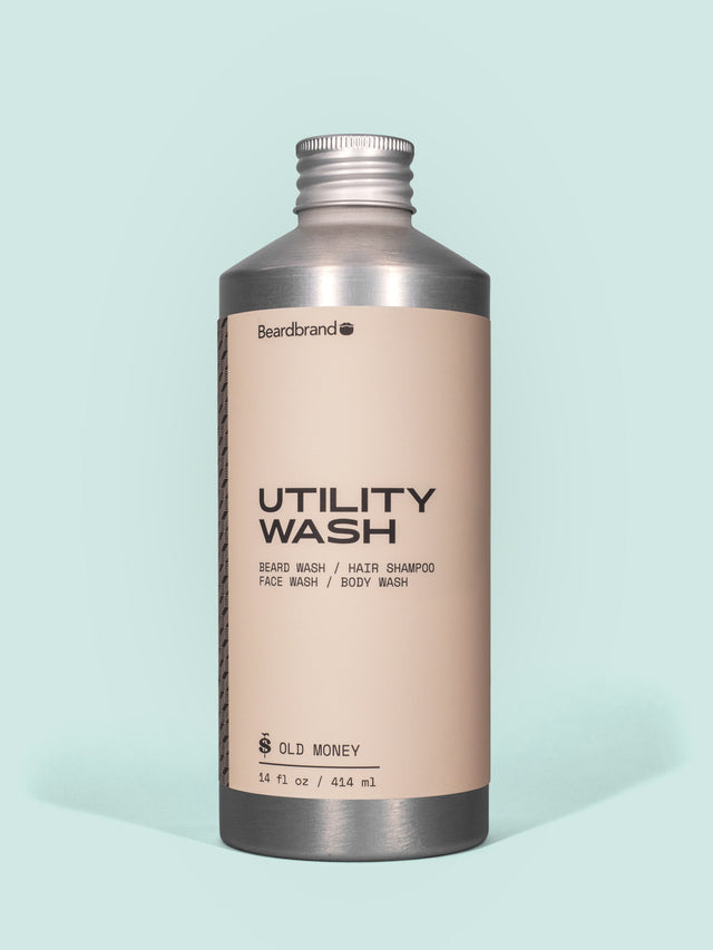 Beardbrand Utility Wash in Aluminum packaging with a screw cap against a light blue background.