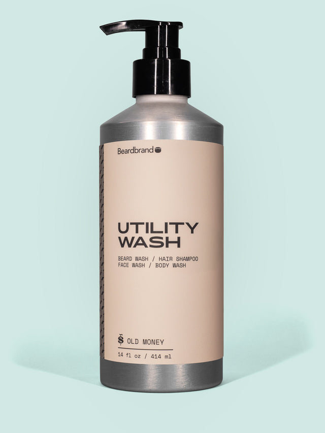 Beardbrand Utility Wash in Aluminum packaging with pump dispenser against a light blue background.